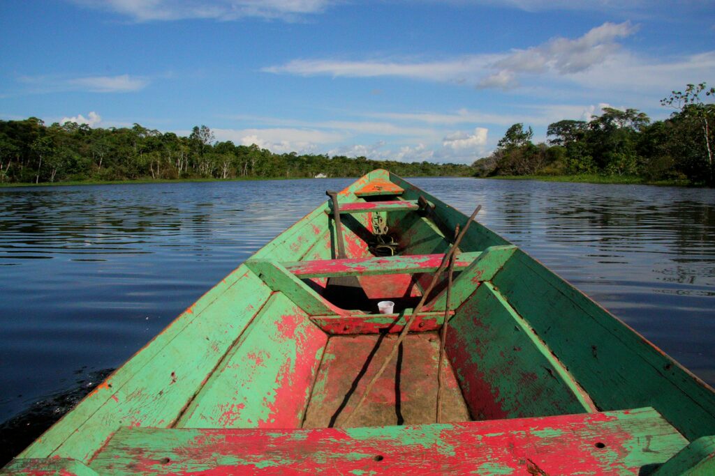 An old wooden row boat on the Amazon River looks very natural and at home but note the discarded plastic mug, even here.