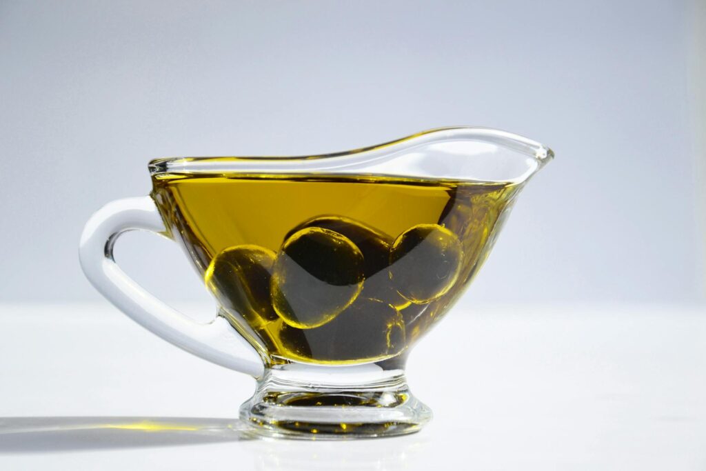 first image: greek olive oil in a glass serving jar; second image: Tzatziki in a Ceramic Bowl; third image: greek bottles of wine corked