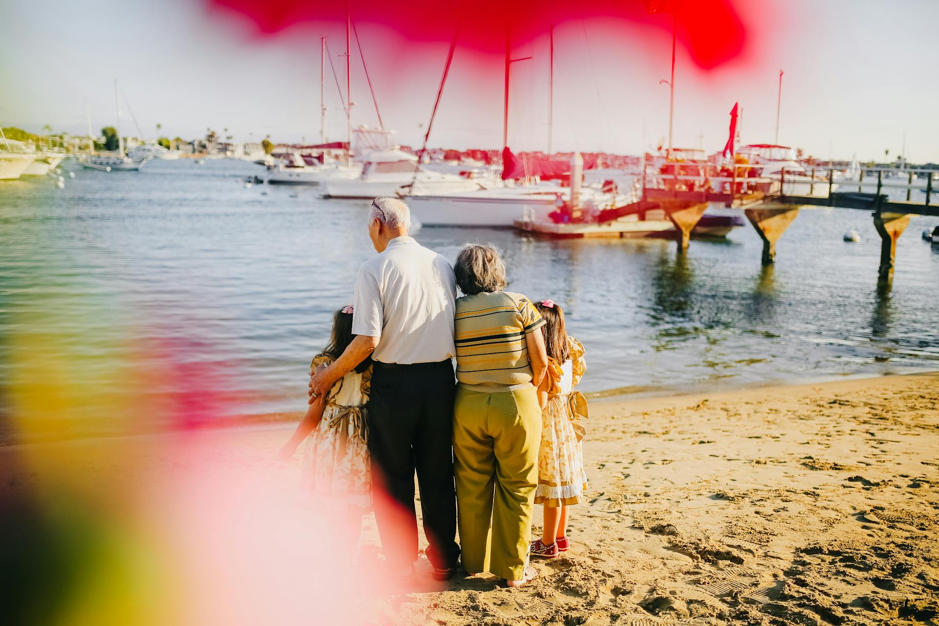 protecting your family's moments when you travel. Two grandparents embrace two of their small grandkids on a beach