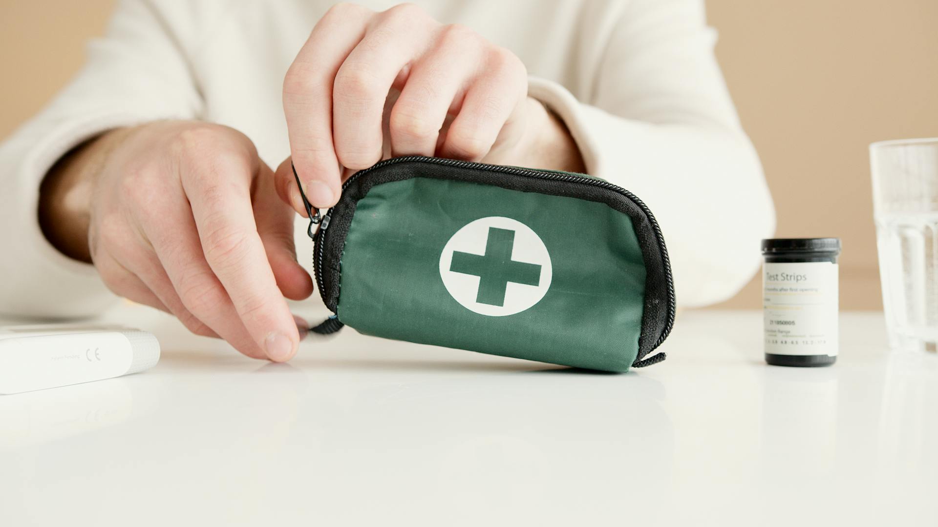 A Person Holding a Green and Black Medical Pouch