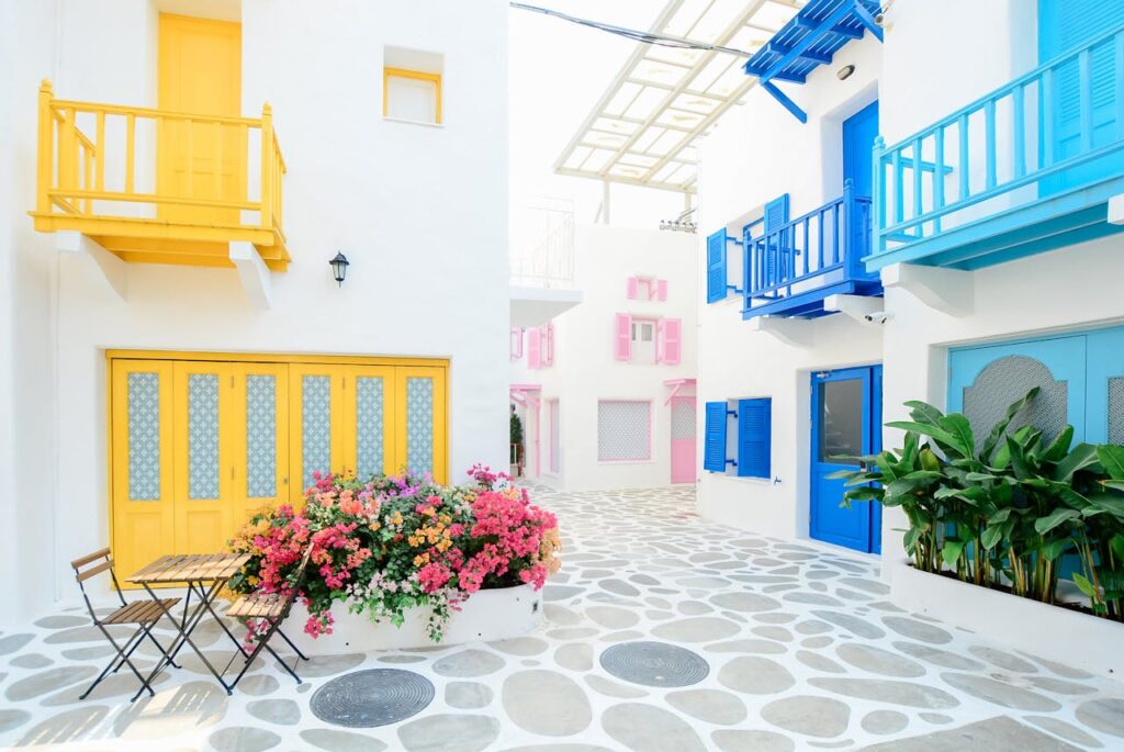 Architectural Photography of Three Pink, Blue, and Yellow Buildings in Greece