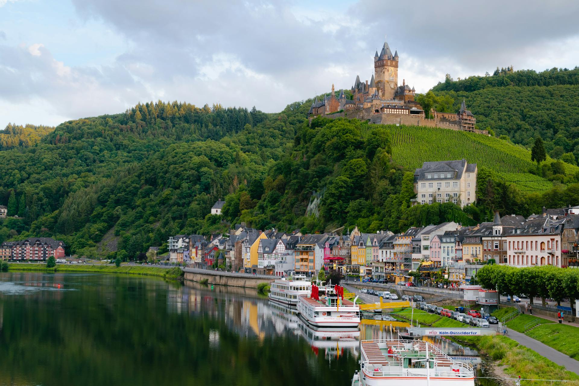 castle on a hill over a village next to a river