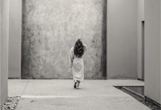 woman walking away from the camera wearing a robe at a peaceful spa