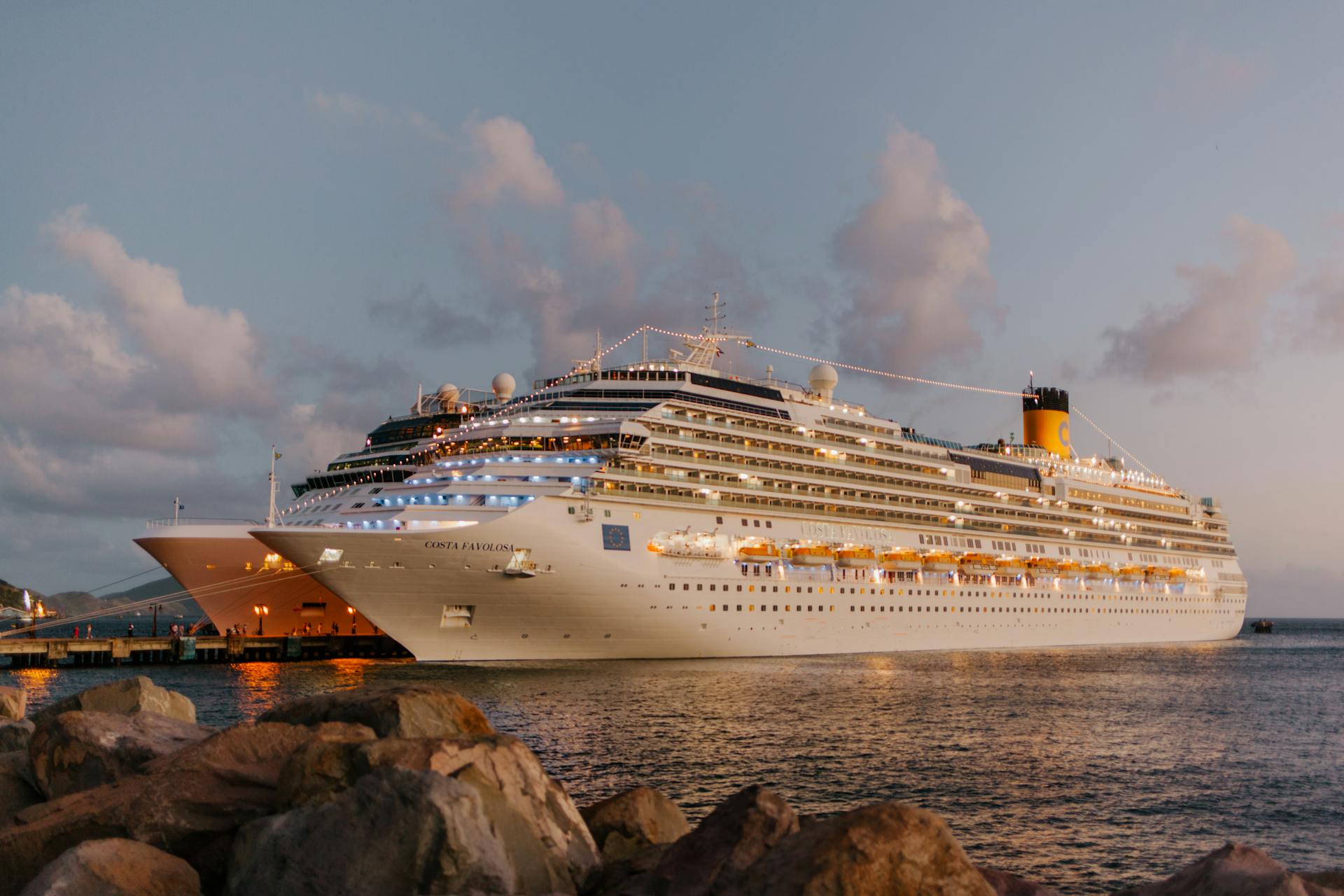 White cruise ship on sea tied to shore