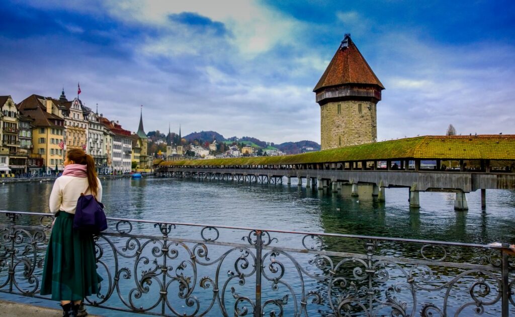 Woman Standing Against Handrails Beside Body of Water in Lucerne Switzerland