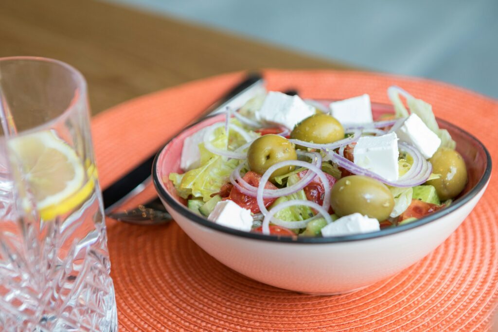 a greek salad in a blue ceramic bowl