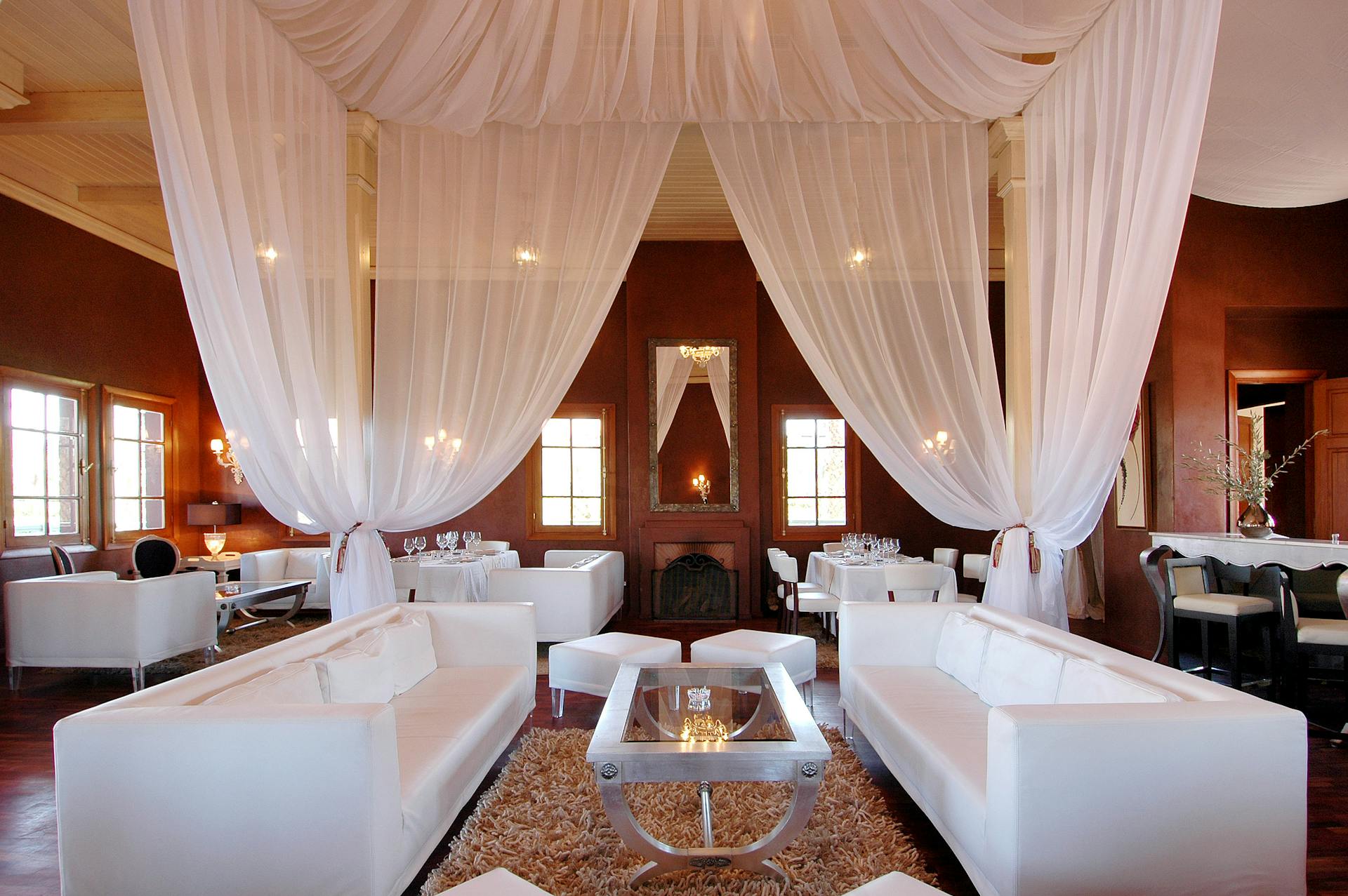 a luxury fine dining restaurant with white couches and white curtains in Marrakech