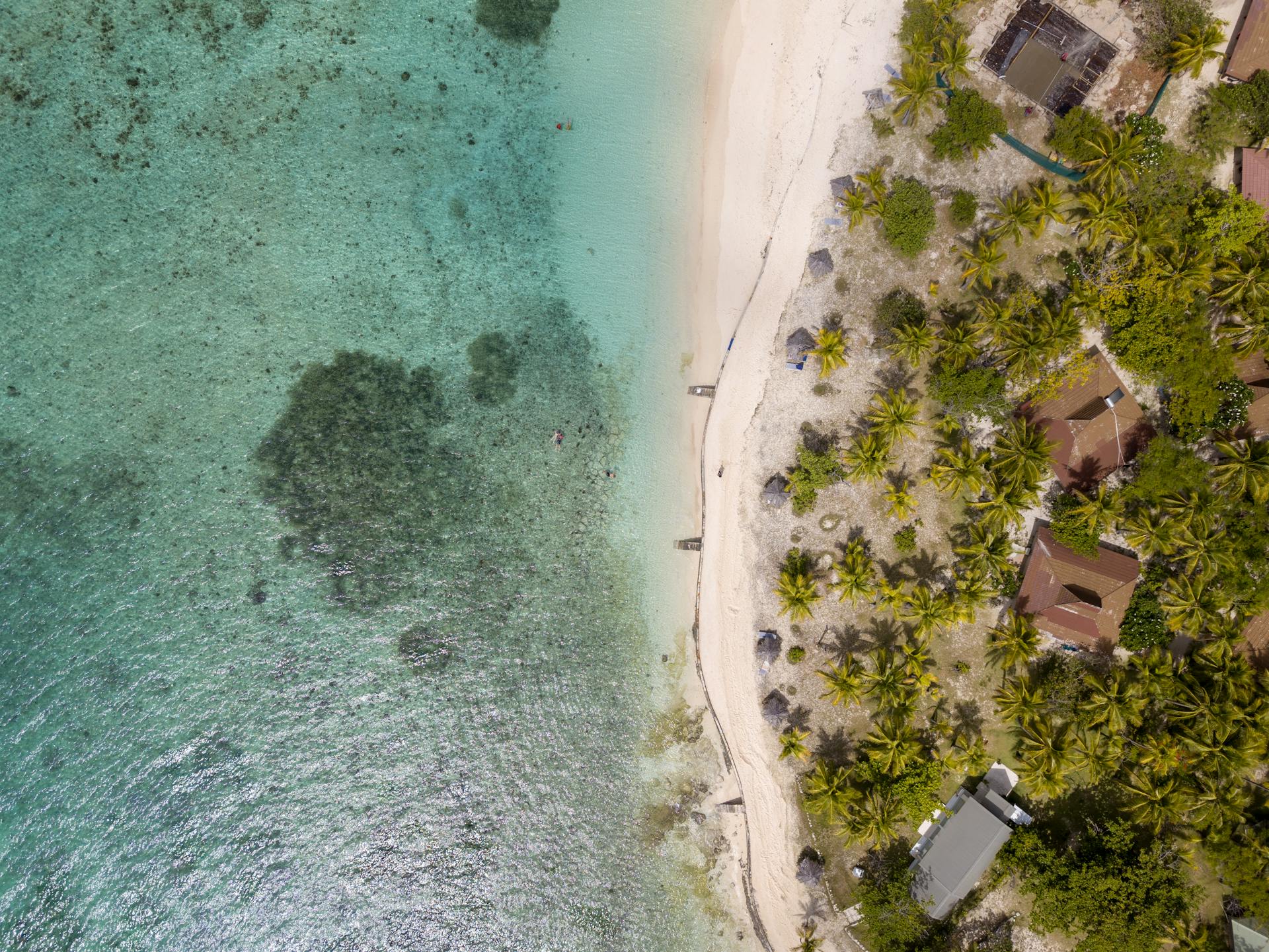 aeriel view of crystal clear water and beach huts in fiji