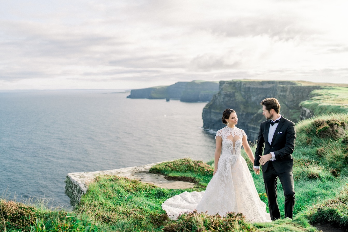 bridge and groom standing at the cliffs of moher in ireland