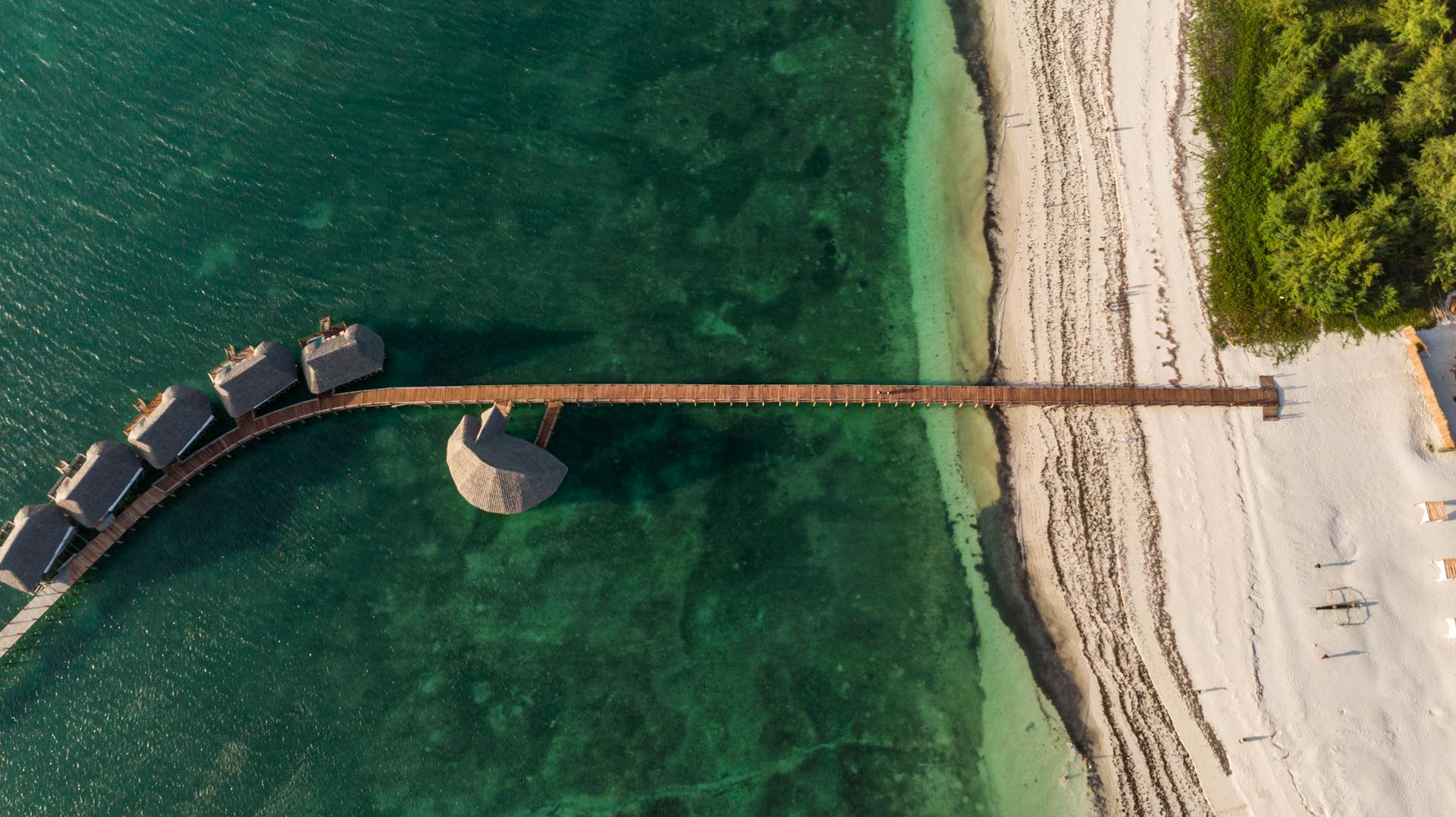 drone picture of a beautiful beach with green water in tanzania