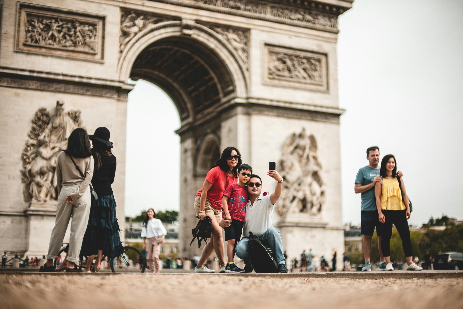 family taking a selfie at the arc de triomphe in paris