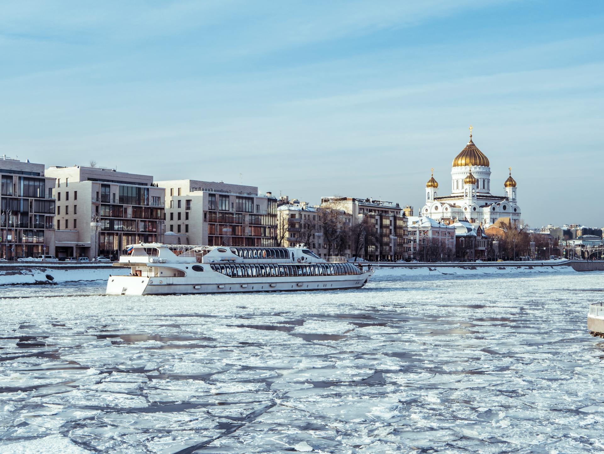 river cruise boat travling down an icy river in russia