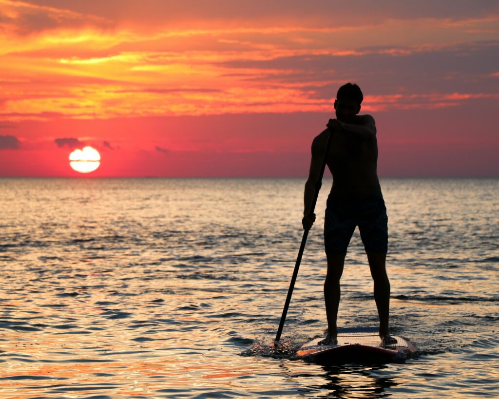 stand up paddleboarding during sunset