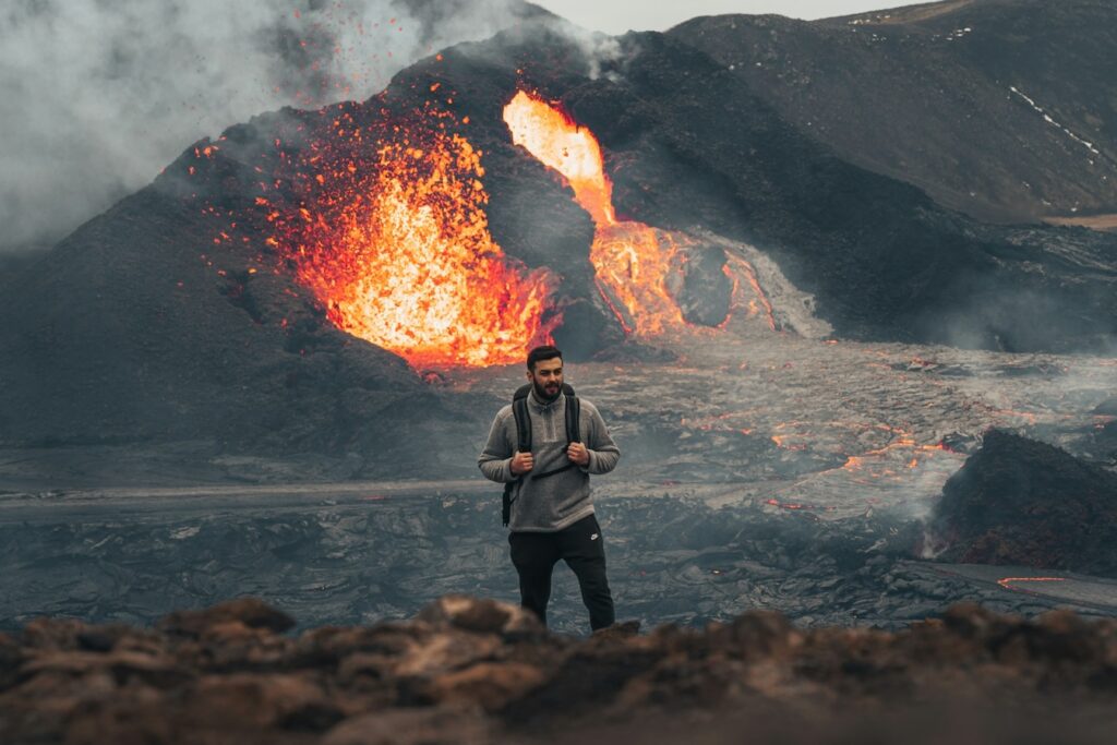 man hiking near active volcano in iceland