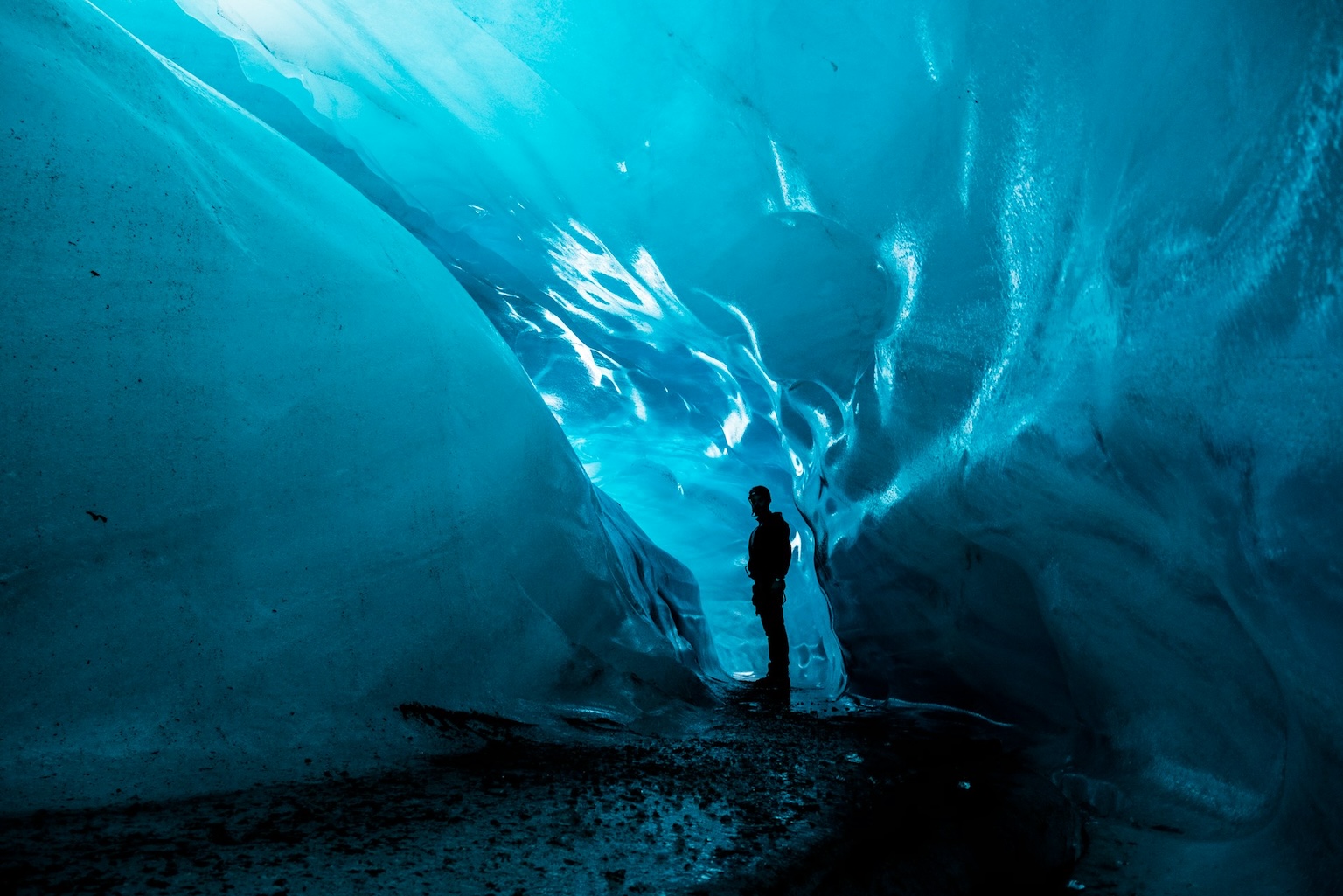 man standing inside a glacier