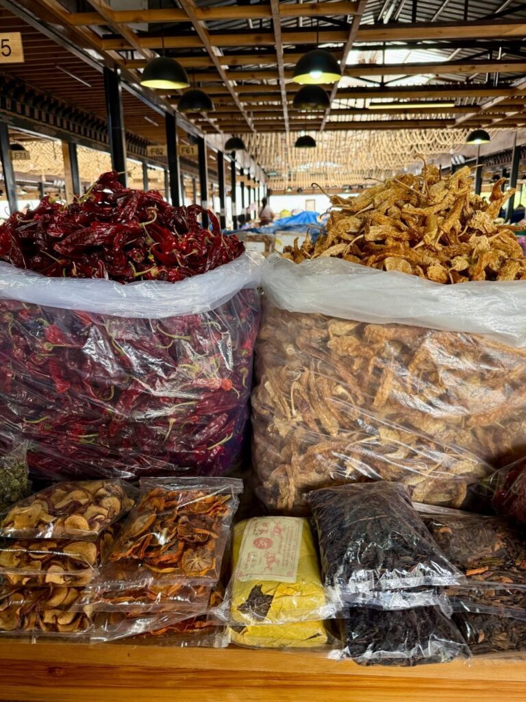 Sacks of dried red chilies beside other dried goods in a covered market in Bhutan