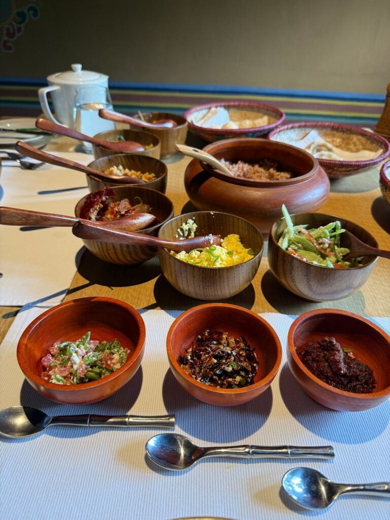 Wooden bowls of chili paste, relishes and condiments set out on a table in Bhutan